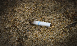 cigarette butt contaminant ocean pollution plastic waste environmental concern trash item on beach